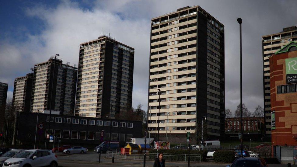 A woman walks in front of the Seven Sisters residential tower blocks