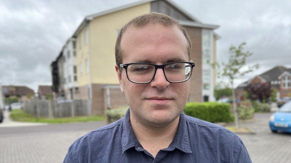 Ben Appleby standing outside some flats