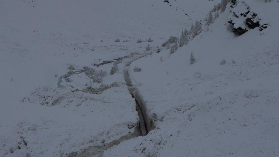 Workers cut through snow wall on the Bessans to Bonneval-sur-Arc road in France