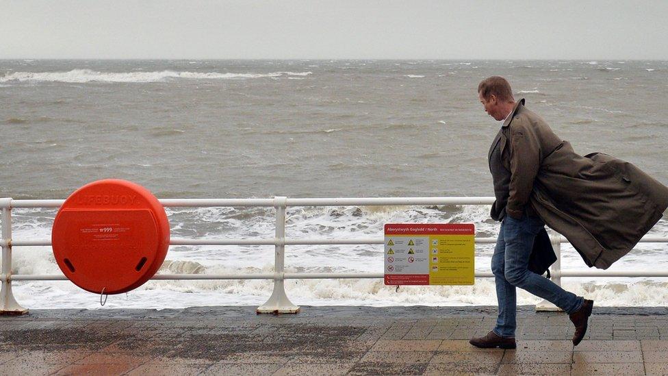 A man walks along the promenade in Aberystwyth, Wales, on 17 November