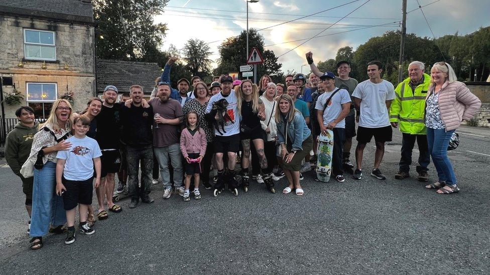 Mr Coburn surrounded by his family in friends, lining up for a photograph in the evening light.