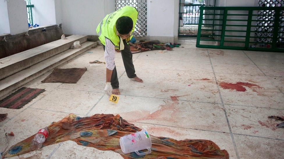 A security official inspects the scene of a bomb blast at Hussaini Dalan in Dhaka, Bangladesh, on 24 October 2015