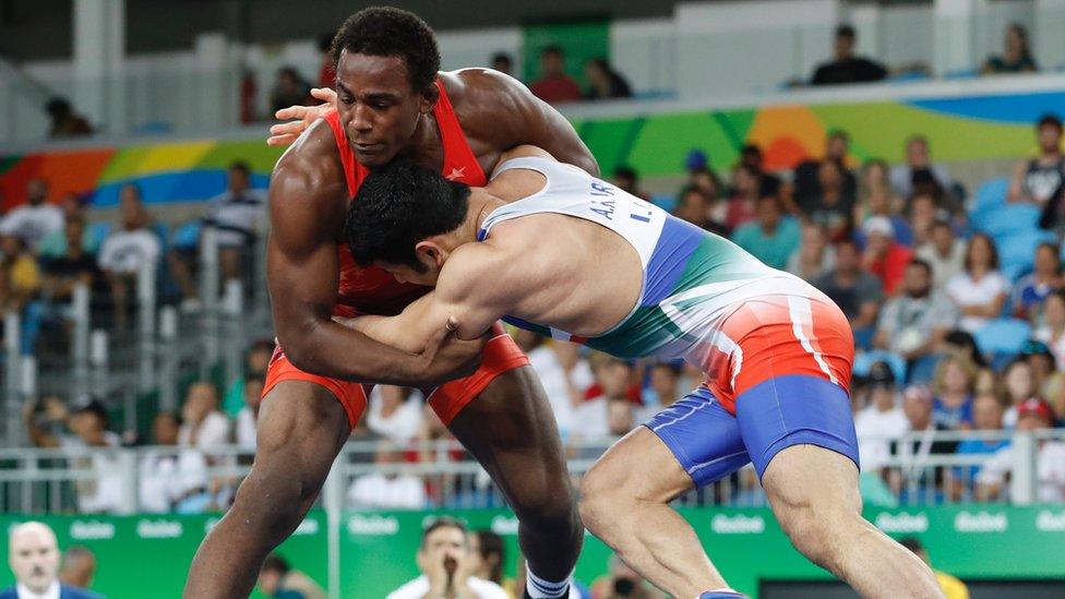 USA's J'den Michael Tbory Cox (red) wrestles with Iran's Alireza Mohammad Alireza Karimachiani in August game