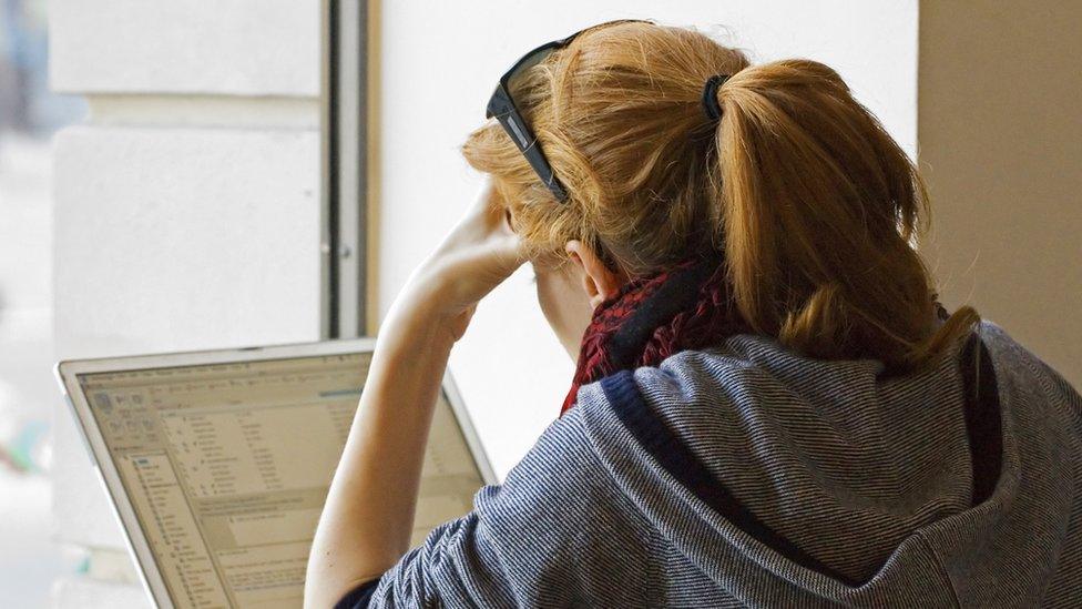 Student leaning over laptop