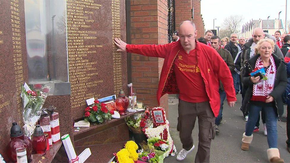 A fan touches the Hillsborough memorial