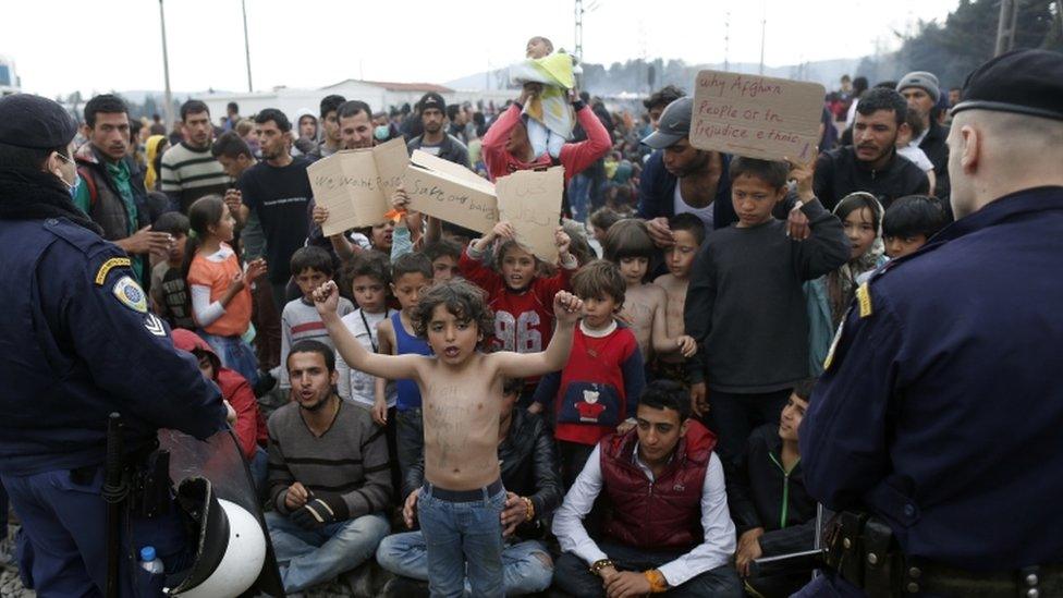 Migrants shout slogans in front of police officers while blocking a railway during a protest demanding the opening of the border between Greece and Macedonia in the northern Greek border station of Idomeni, Greece, 21 March 2016