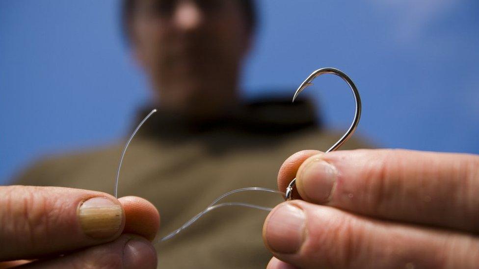 A man tying a fishing line to a hook