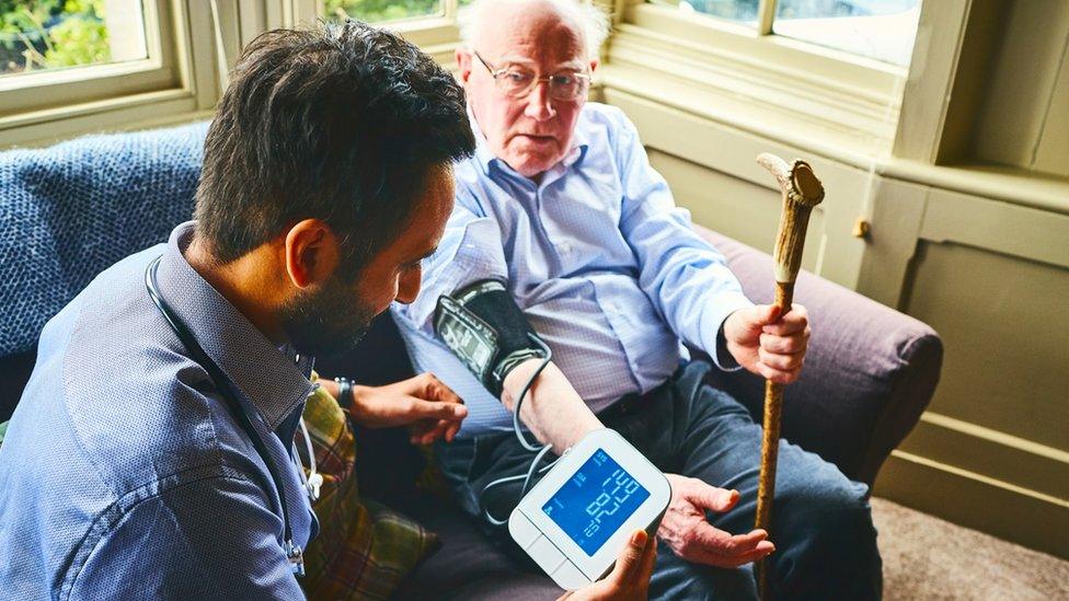 Elderly man having his blood pressure taken