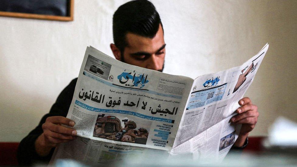 A Jordanian man reads a local newspaper in the capital Amman, April 2021