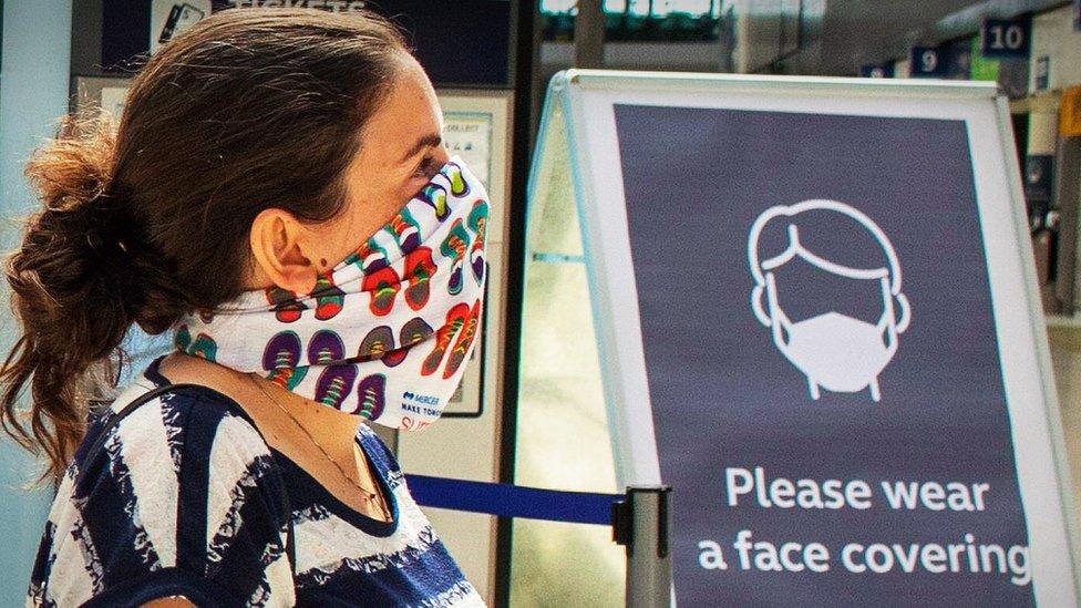 Woman at railway station wearing a face mask