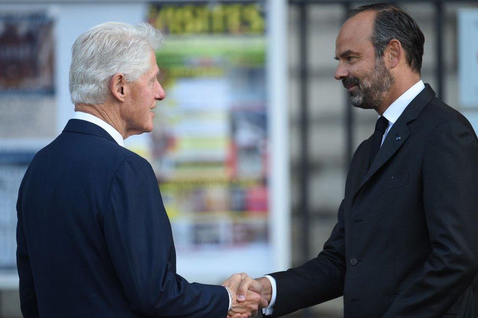 US former President Bill Clinton is greeted by France's Prime Minister Edouard Philippe as he arrives to attend a church service for former French President Jacques Chirac on 30 September 2019.