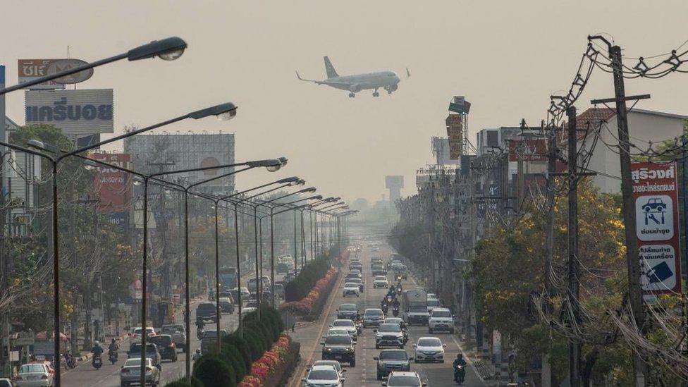 Airplane flies above polluted Chiang Mai, Thailand.