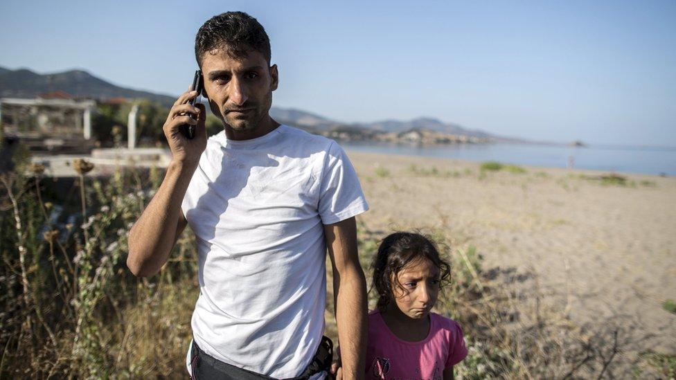 Ihab, a 30-year-old Syrian migrant, reacts as he talks on the phone with his mother in Germany after arriving on the Greek island of Lesbos on 11 September 2015