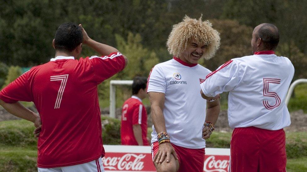 Colombian former football star Carlos Valderrama (C) talks with his teammate Diego Leon Osorio (R) during a friendly match against the 'More sport-less mines' team, composed by victims of landmines, in the framework of the WC2011 U-20 tournament, in Bogota, on July 27, 2011