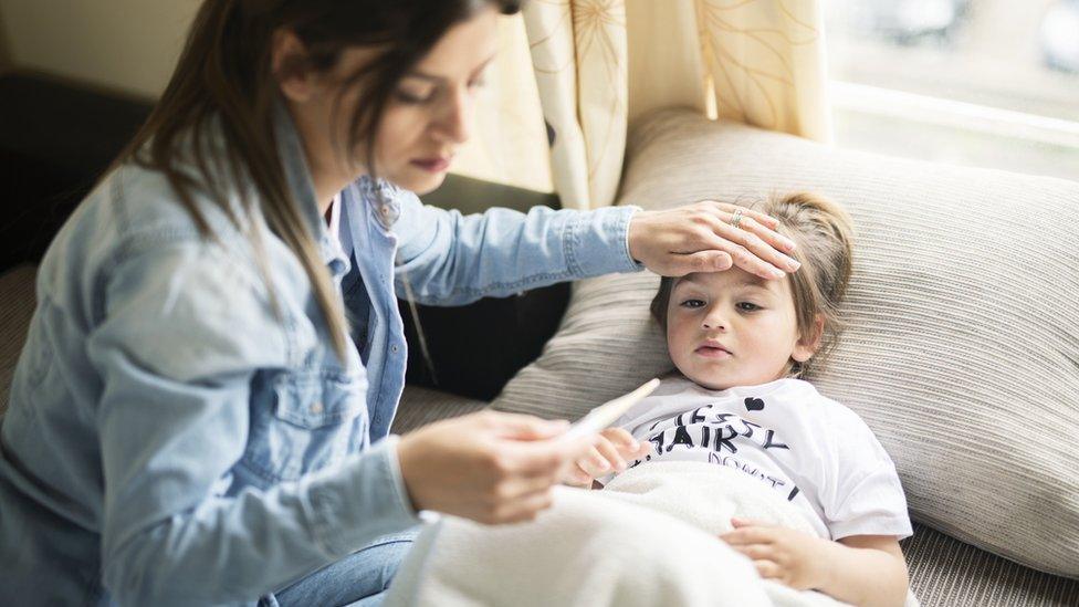 Mother taking her child's temperature