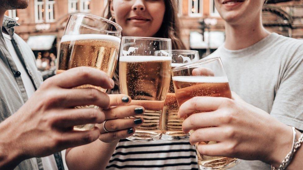 people holding beer glasses