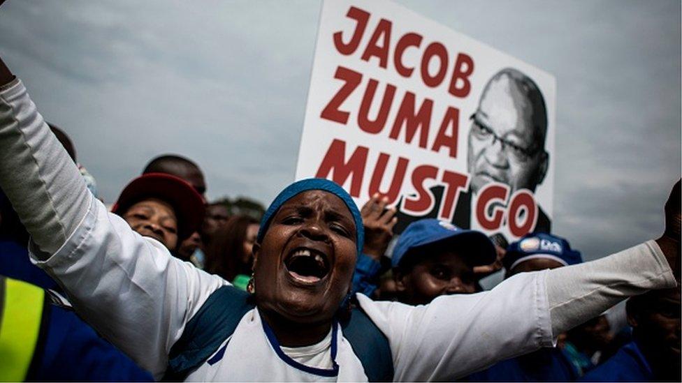 A Democratic Alliance (DA) party's supporters holds a placard reading 'Jacob Zuma must go' during a march against South African president Jacob Zuma on April 7, 2017 in Johannesburg.