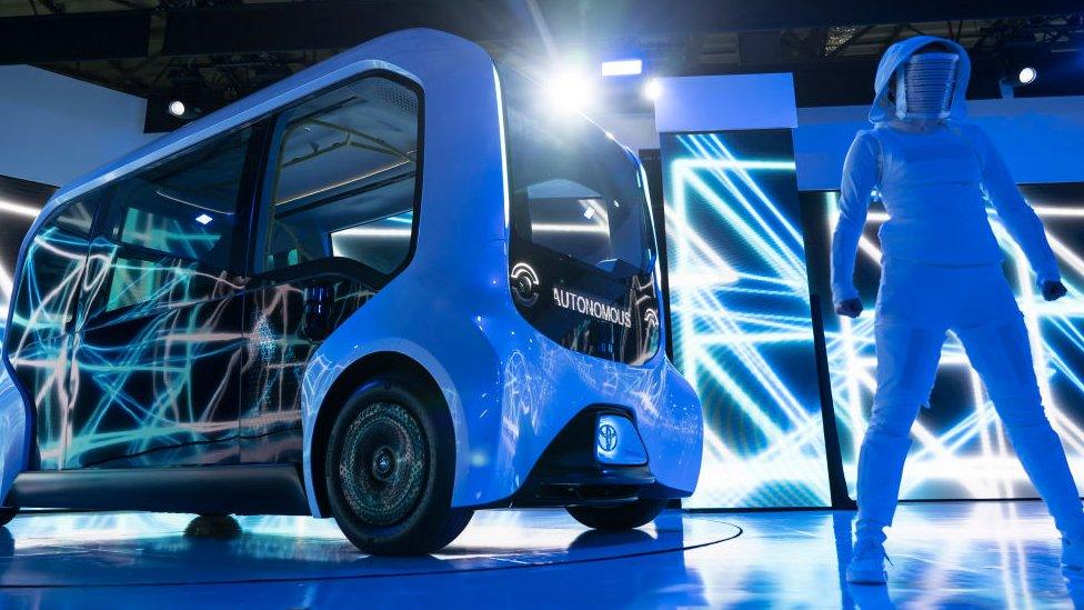 A dancer performs next to Toyota's e-Palette Concept autonomous vehicle during a press conference at the Tokyo Motor Show 2019.