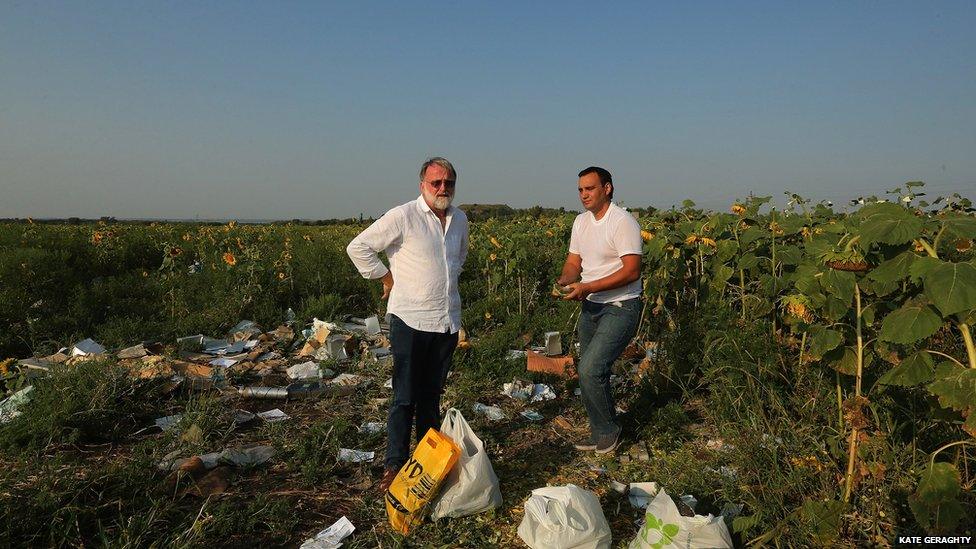 Journalist Paul McGeough (left) with bags of sunflower seeds at the MH17 crash site in the Ukraine