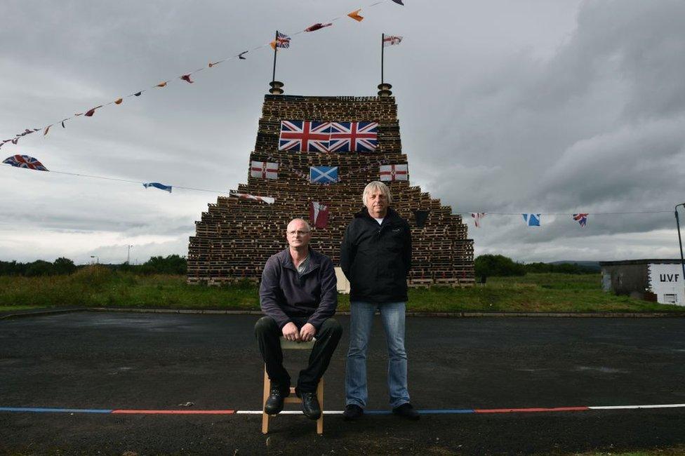 Stewart McClelland (L) and Winston Wylie (R) proudly display their finished bonfire on the Ballykeel 2 estate on July 10, 2017 in Ballymena, Northern Ireland. The