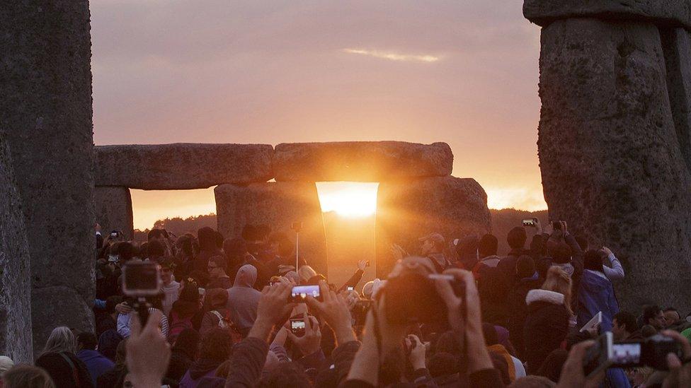 People gather at Stonehenge to experience the sun rising on the longest day of the year