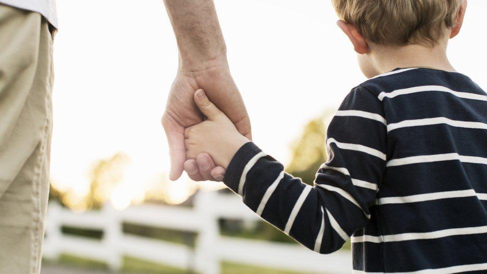 Father holding child's hand