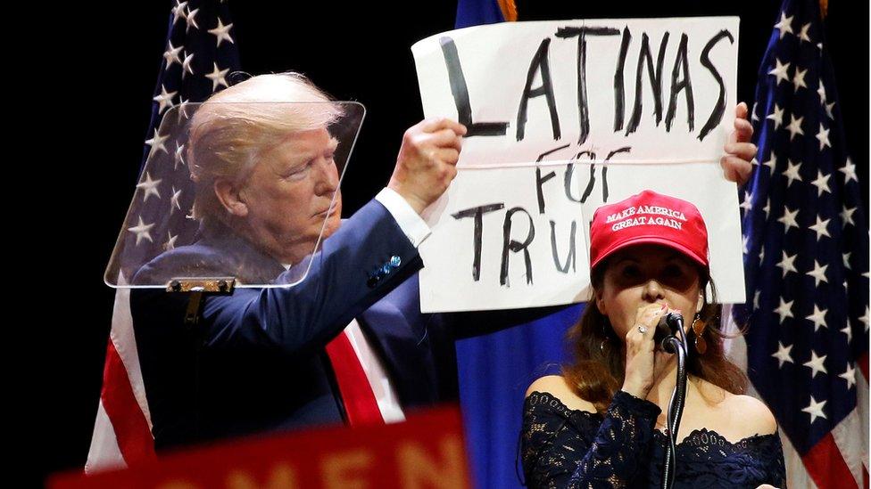 A woman joins Republican presidential nominee Donald Trump as he holds up a "Latinas for Trump" sign during a campaign rally at the Venetian Hotel in Las Vegas, Nevada, U.S. October 30, 2016