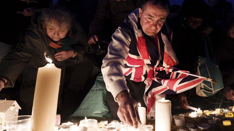 People lighting candles