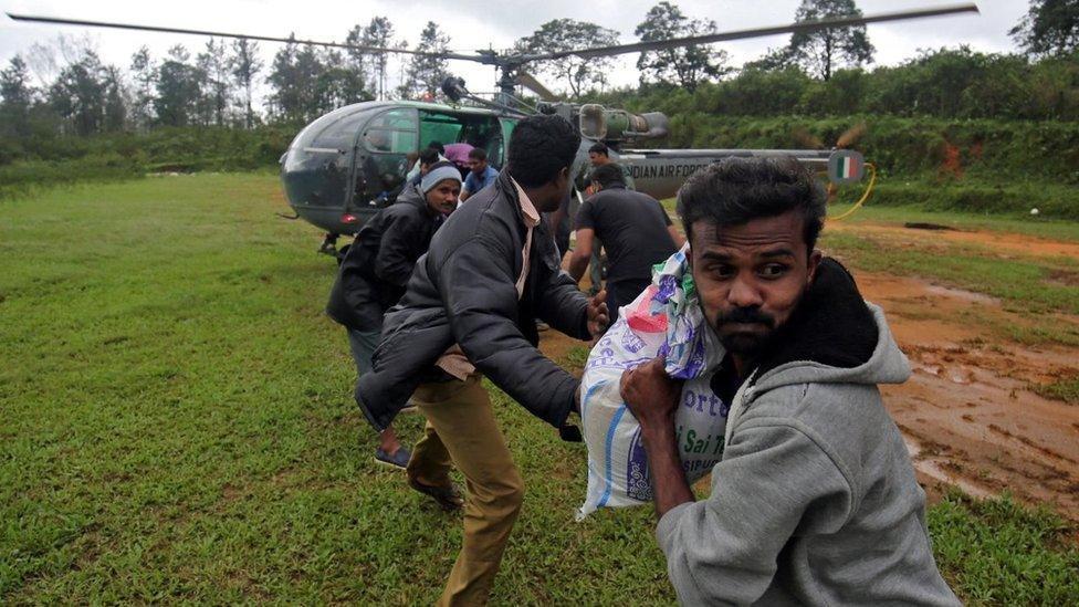 People unloading goods from an army helicopter