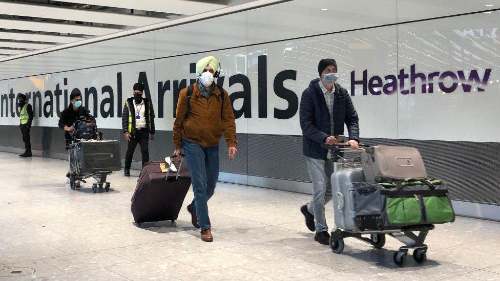 Passengers are escorted through the arrivals area of terminal 5 towards coaches destined for quarantine hotels, after landing at Heathrow airport