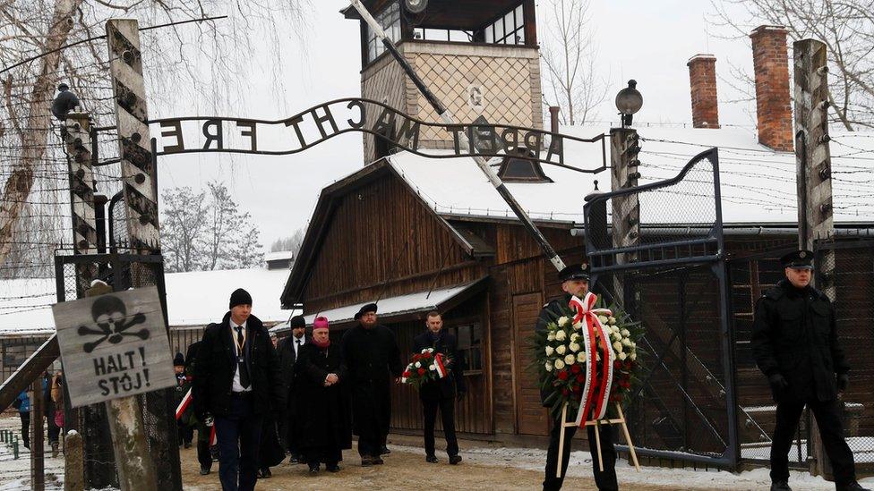 People arrive to lay wreaths at the "death wall" at the former Nazi German concentration and extermination camp Auschwitz