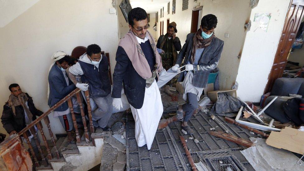 Rebels carry the body of someone killed by air strikes on a Houthi-run prison in Sanaa, Yemen (13 December 2017)