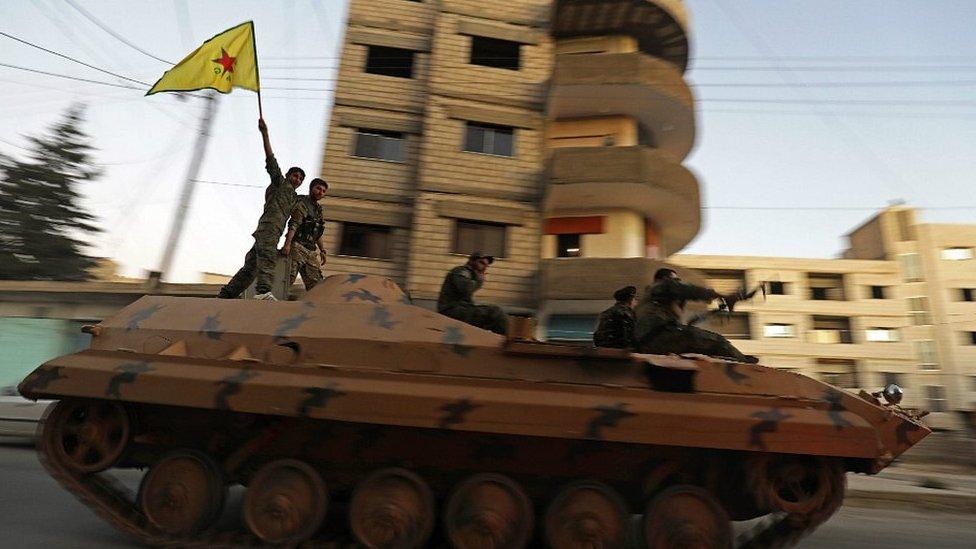 YPG fighters celebrate after Syrian Democratic Forces (SDF) announced they had taken full control of Raqqa from the Islamic State group on October 17, 2017