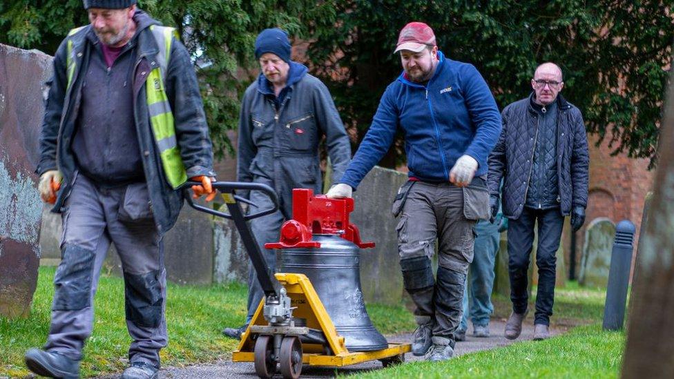 One of the bells being taken back into the church