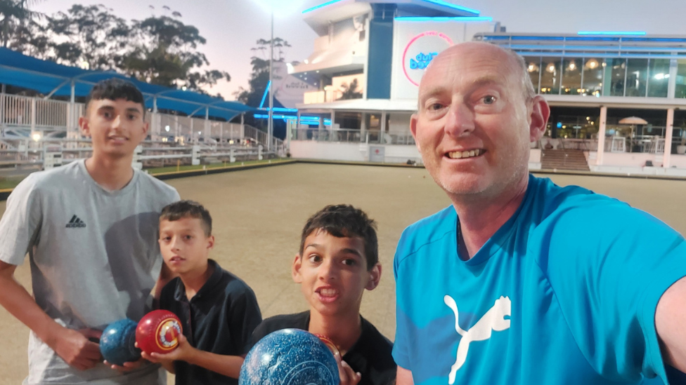 Dave with his sons Jake, Thomas, and Dylan. All three are holding bowls while on holiday in Australia.