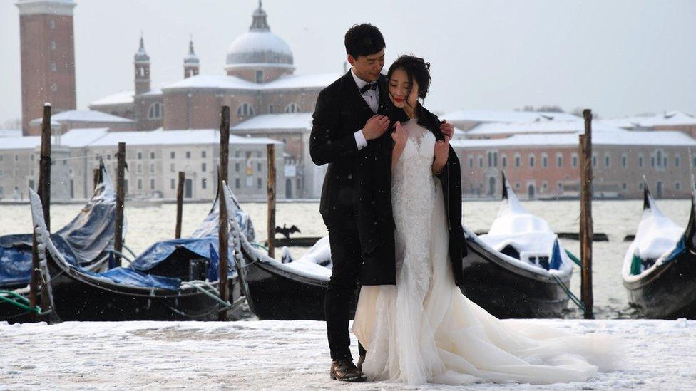 A couple poses in St. Mark's Square in Venice