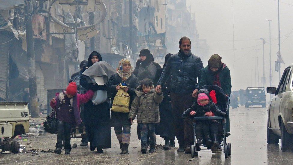 Syrian residents arrive in Aleppo's Fardos neighbourhood after fleeing the violence of Bustan al-Qasr, 13 December 2016