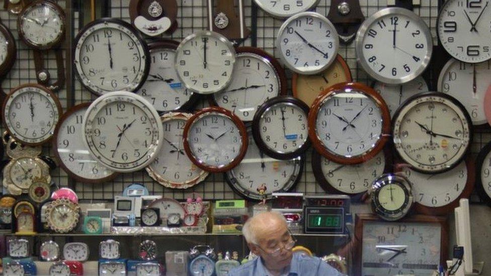 A watch and clock vendor sits in his shop in Seoul on 29 July 2015