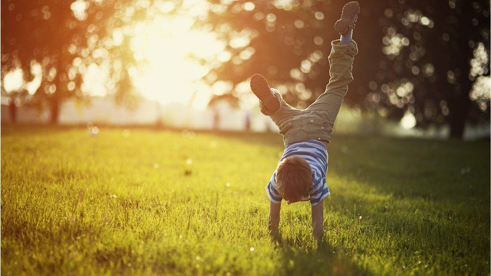 A-boy-does-a-handstand-outside.