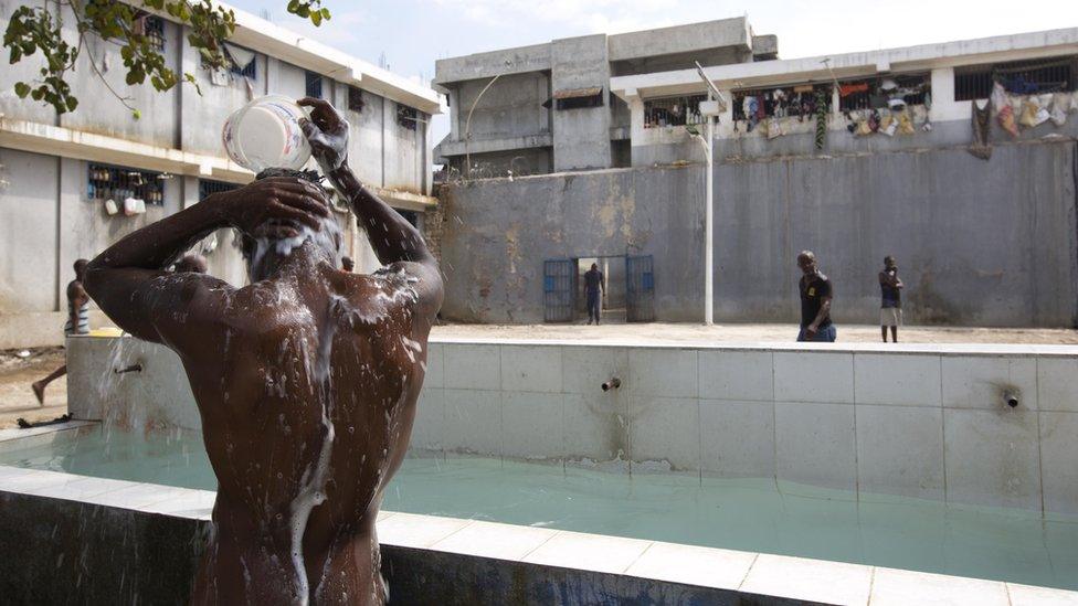 A prisoner bathes during recreation time inside the National Penitentiary in downtown Port-au-Prince