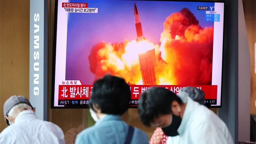 People watch a TV broadcasting file footage of a news report on North Korea firing what appeared to be a pair of ballistic missiles off its east coast, in Seoul