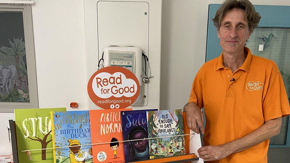 Michael Loader standing next to a book display