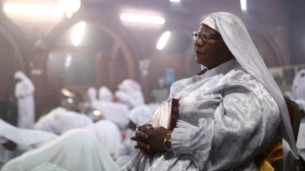 Worshippers pray during a Good Friday Lent church service at the Eternal Sacred Order of Cherubim and Seraphim Church in London