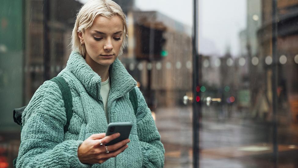 Person using smartphone in street