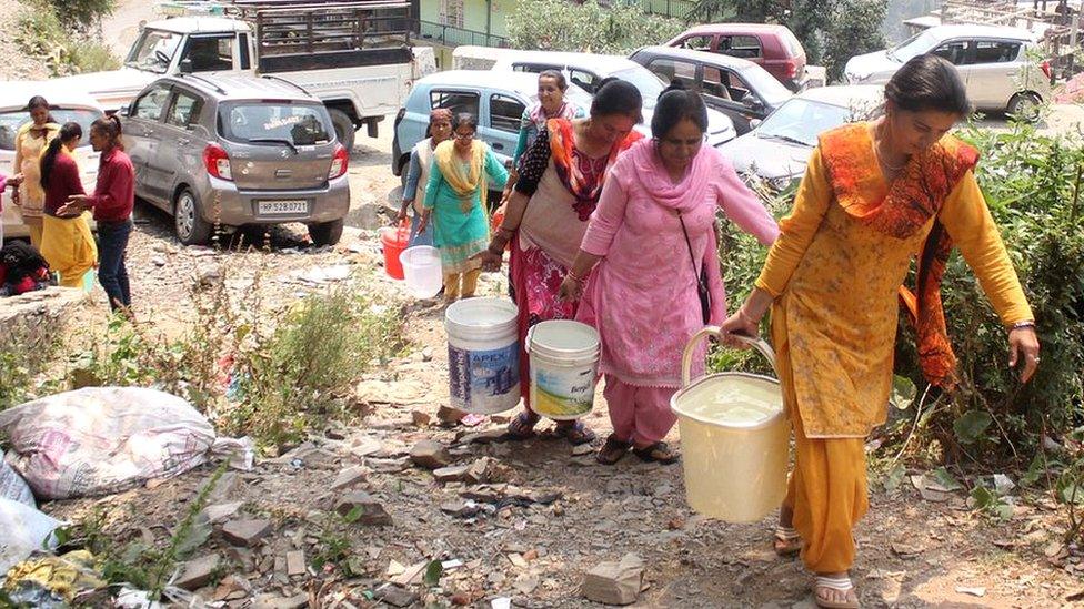 Women carrying buckets of water in Shimla