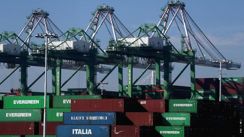 Stacks of shipping containers sit in a berth at Oakland, USA