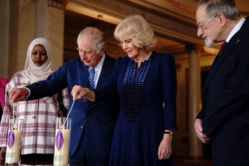 King Charles III and the Queen Consort light a candle at Buckingham Palace, London, to mark Holocaust Memorial Day, alongside Holocaust survivor Dr Martin Stern and a survivor of the Darfur genocide, Amouna Adam