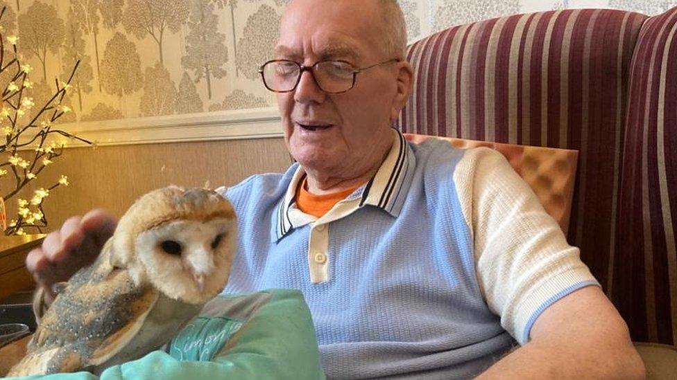 A care home resident strokes Bonzo