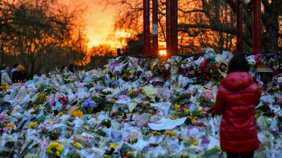 People visit the memorial site at the Clapham Common Bandstand,