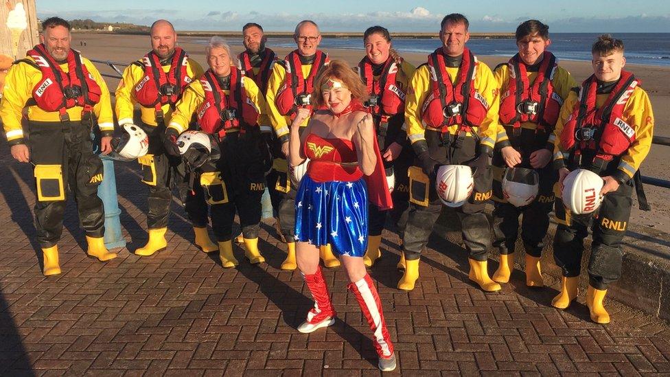 One dipper dressed as Wonder Woman with RNLI volunteers